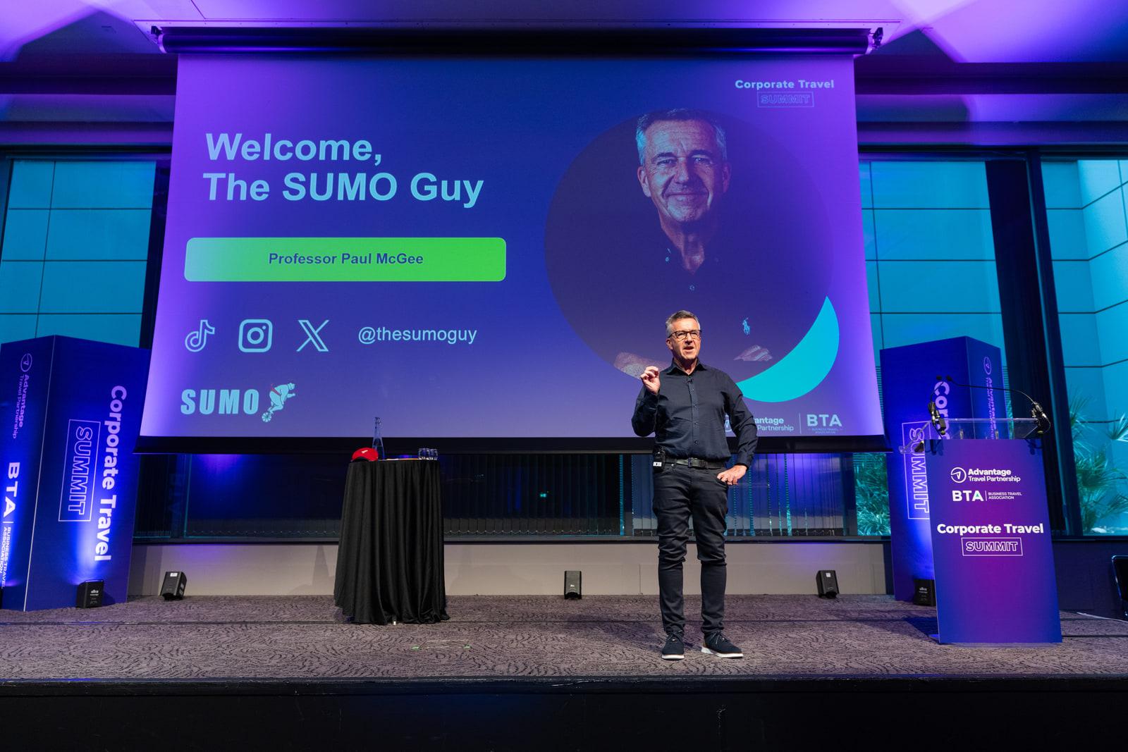 Paul McGee presenting on stage at the Corporate Travel Summit