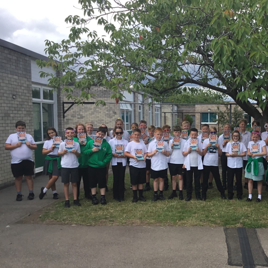 School children holding copies of the YESSS! book